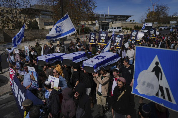 Activists in Jerusalem representing families of Israelis killed during the war in Gaza carry mock coffins covered with Israeli flags meant to symbolise the price Israel will pay for agreeing to a ceasefire with Hamas.