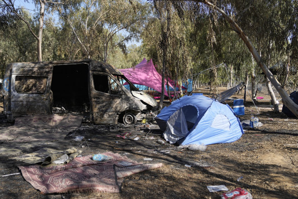 Tents, debris and a burned out van are scattered about the site of a music festival near the border with the Gaza Strip days after October 7.