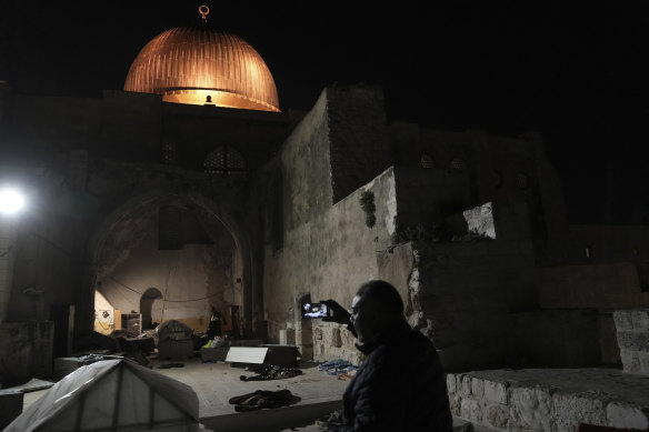 A Palestinian worshipper films the aftermath of a raid by Israeli police at the al-Aqsa Mosque compound on Wednesday.