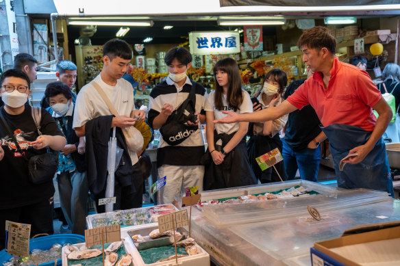 Masato Miyake of Miyake Suisan serves customers at the Tsukiji fish market in Tokyo. 