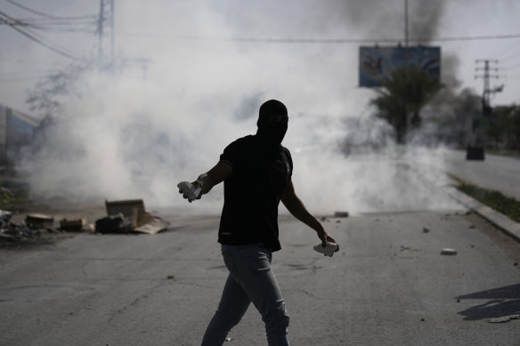 A Palestinian carries stones during clashes with Israeli forces near the West Bank city of Jericho.