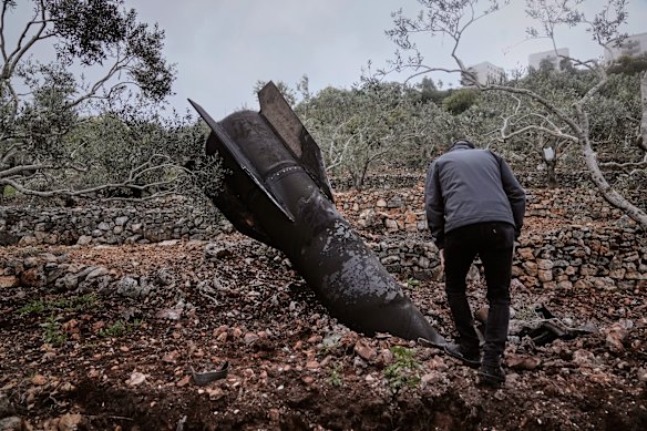 A man inspects the remains of an Iranian missile that landed near the West Bank village of Marda late last month. 