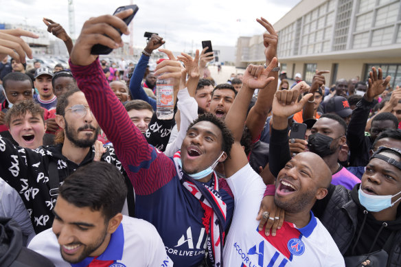 Paris Saint-Germain supporters wait for Lionel Messi to arrive at Le Bourget airport.