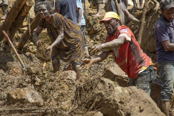 Villagers search through a landslide in Yambali village, in the Highlands of Papua New Guinea.