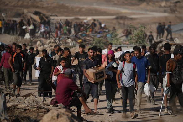 Palestinians carry humanitarian aid packages distributed by the Gaza Humanitarian Foundation on Thursday.