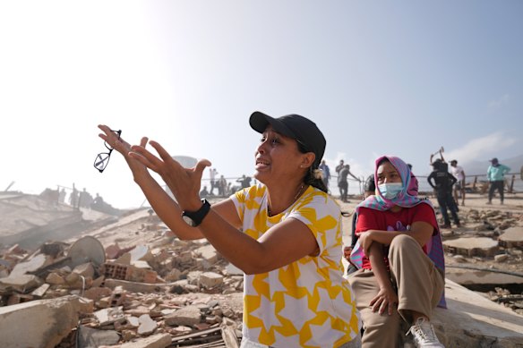 People search for missing relatives at the collapsed building where they lived in La Guaira.