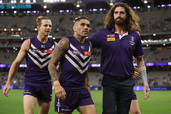 Michael Walters walks from the field with Nat Fyfe and Alex Pearce after their defeat. 