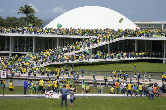 Protesters, supporters of Brazil’s former president Jair Bolsonaro, storm the National Congress building in Brasilia, Brazil, on Sunday (Monday AEDT).