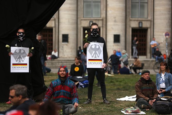 Protesters hold signs referring to the Grundgesetz, or German constitution known as the basic law, as they demonstrate against restrictions designed to stem the spread of the coronavirus.