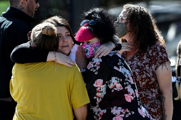 Zane Mellor’s mother Georgie Gardam (centre in white T-shirt) is comforted at her son’s funeral in Devonport.