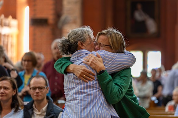 Two churchgoers embrace at a service  for Haines in Wangaratta.
