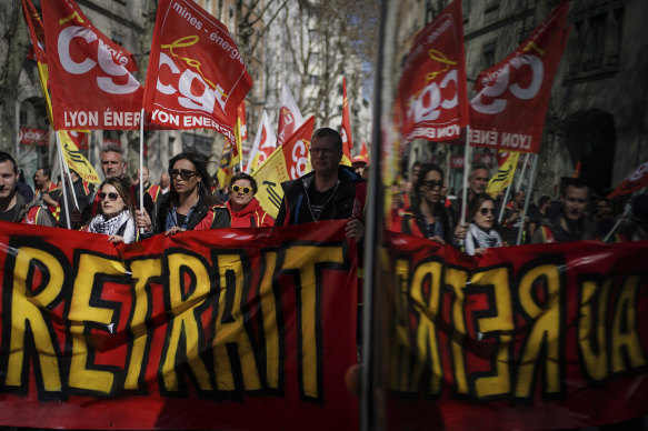 Railway workers hold a banner reading “Until withdrawal” during a demonstration in Lyon.