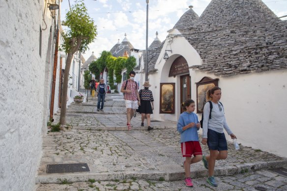 People stroll in the historic centre of Trulli, Puglia, Italy.