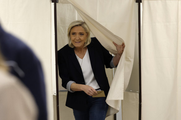 French far-right leader Marine Le Pen exits the voting booth while voting for the European election.