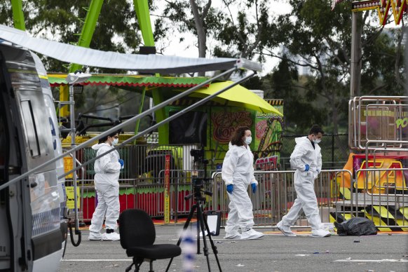 Forensic police walk past closed rides at the Royal Easter Show on Tuesday morning.