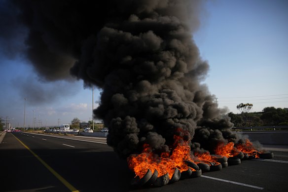 Tyres are set on fire to block a road during a protest near Jerusalem on Sunday.