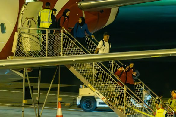 Tim sepak bola wanita Iran turun dari penerbangan Qantas mereka di Sydney, dalam perjalanan kembali ke Iran.