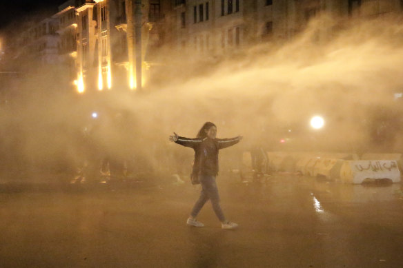 A protester is sprayed with a water cannon  in Beirut.