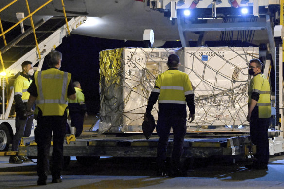 Airport workers unload pallets of the first shipment of the Moderna COVID-19 vaccination as it arrives in Sydney on Friday.