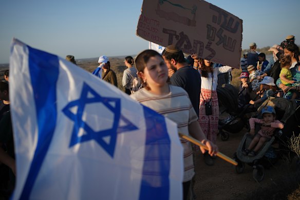 Israeli right-wing activists, one holding a sign “Gaza is ours forever,” attend a rally on Thursday calling for the re-establishment of Jewish settlements in the Gaza Strip.