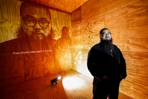 Badiucao with a work from his new exhibition, Disagree Where We Must.