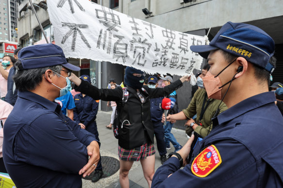 An anti-DPP protester holds up a banner at a political rally in Taipei. 