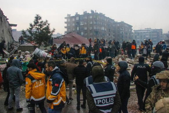 People and rescue teams try to reach trapped residents inside collapsed buildings in Diyarbakir, Turkey