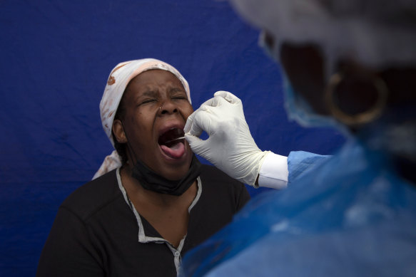 A throat swab is taken from a patient to test for COVID-19 at a facility in Soweto, South Africa.