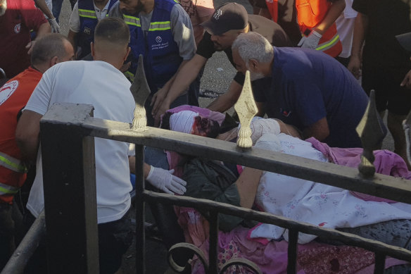 First responders carry a man wounded after his handheld pager exploded, in the southern port city of Sidon, Lebanon.