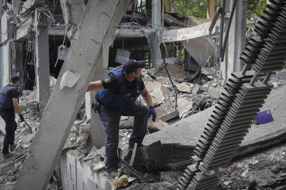 Emergency crews search the site of a bombing in the school where a graduation ceremony, called the Last School Bell, was supposed to take place in Kharkiv, Ukraine, on Thursday.