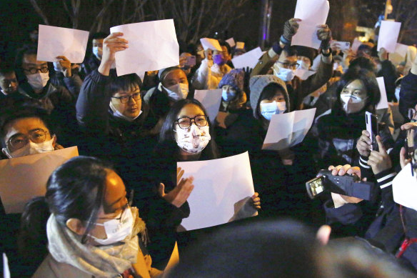 Protesters in Beijing hold blank sheets of paper to symbolise censorship.