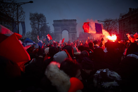 French football fans chant and sing on the Champs Elysees during the World Cup final.