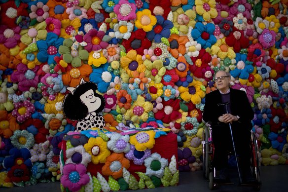 Quino poses next to his character at The World According to Mafalda exhibition in Buenos Aires in 2014.