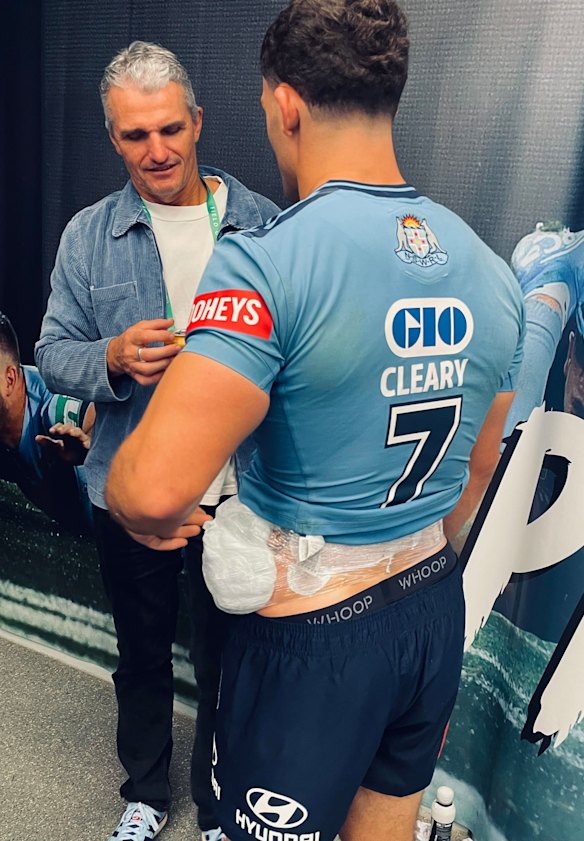 Nathan Cleary celebrates the Blues’ win with his father Ivan with ice strapped to his hip