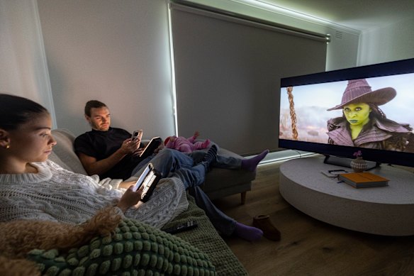 Melita Shala (left) and her husband, Josiah, often catch themselves looking at their phones while watching TV.