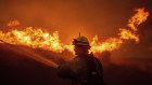 Firefighters tackle the Hughes Fire along a roadside in Castaic in California.
