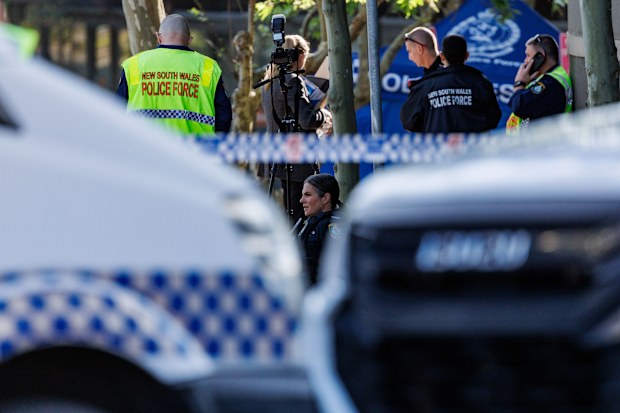Police are seen taking pause in the gutter at the site of the fatal accident.