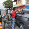 A soldier pats down a driver at a road block in Guayaquil, Ecuador.