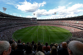 A bumper MCG crowd stands for a minute’s silence.