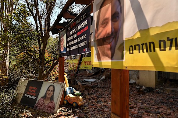 Photographs of a man who was murdered (left), a man taken hostage (right), and a woman, who was taken hostage and then released, in front of their home in Kibbutz Be’eri.