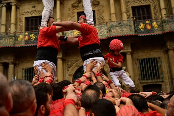 Members of “Castellers” try to complete their human tower during an exhibition, in Pamplona, northern Spain.