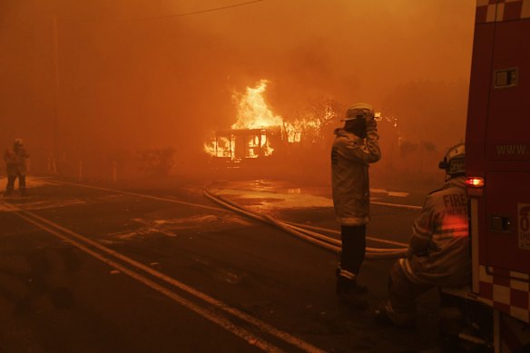 Firefighters rest after fire tore through their defences and destroyed numerous buildings all around them in Bilpin as the Grose Valley fire hit in 2019. 