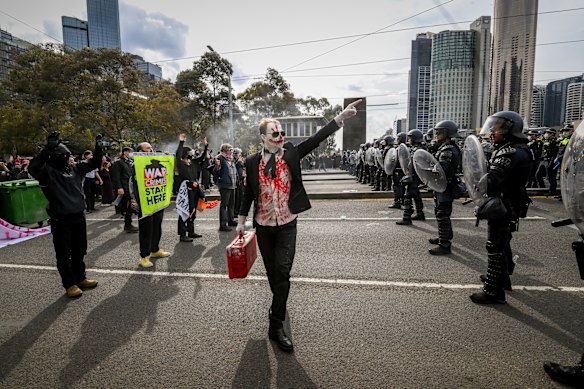 A protester points to police.