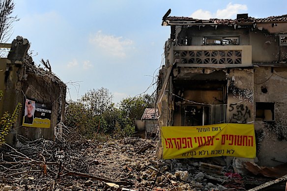 An image of Israeli hostage Itay Svirsky on a banner with the words “Bring Itay Svirsky’s body. We don’t give up till everyone comes back” (left). Another banner (right) states, “The hostages hurt because they were abandoned! We won’t forget and we won’t forgive”. The banners are on destroyed homes in Kibbutz Be’eri where 101 civilians and 31 security personnel were killed by Hamas on October 7. Svirsky died in Hamas captivity in Gaza.