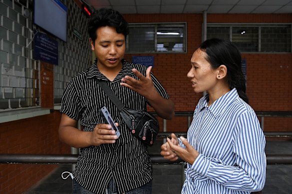 Lakshin Tamang (left) and Rashmi Tamang look at a photo of their relative Sidar Tamang, who is recovering in TU Teaching Hospital in Kathmandu after surviving the Nepal flood disaster. They are still waiting for news of Sidar Tamang’s 12-year-old old son, who is still missing.