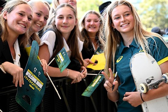 Ruby Trew poses for a photo with schoolchildren at Tumbalong Park on Friday.