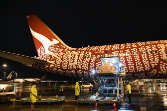 The extra Pfizer doses are unloaded from a Qantas plane last night. 