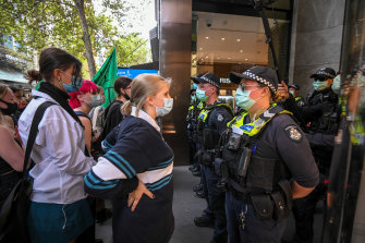 Police clash with protesters after a breakaway group rallied outside the Liberal Party headquarters in Melbourne.