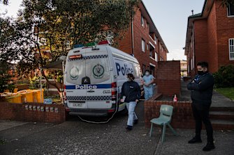 Health workers leaving an apartment block in Campsie, Sydney, earlier this morning. 