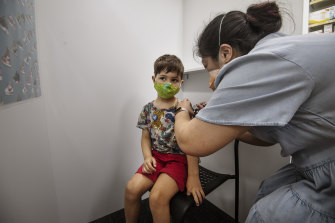 Leichhardt pharmacist Christine Kelly administers a COVID-19 vaccine to 5-year-old Felix Robson.